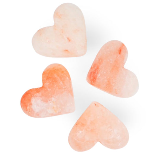 Heart-shaped Himalayan Salt Body Stones with a pinkish-orange hue on a white background